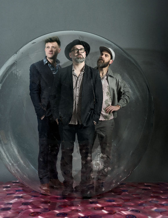 3 hommes dans une bulle en verre.